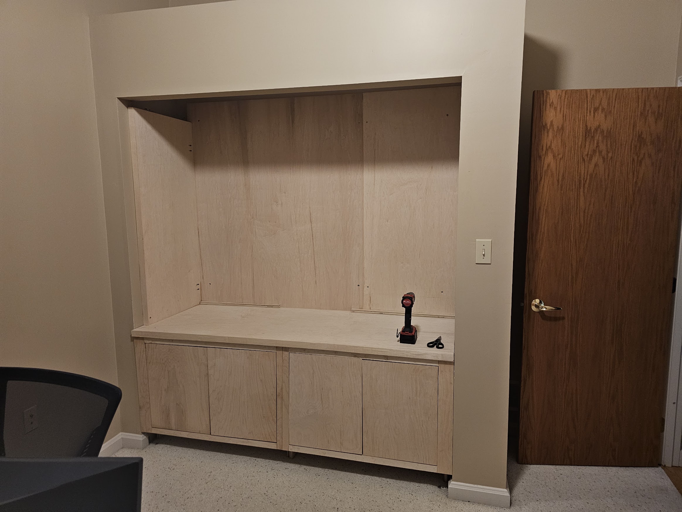 Plywood back wall panels installed with visible horizontal seams across the middle