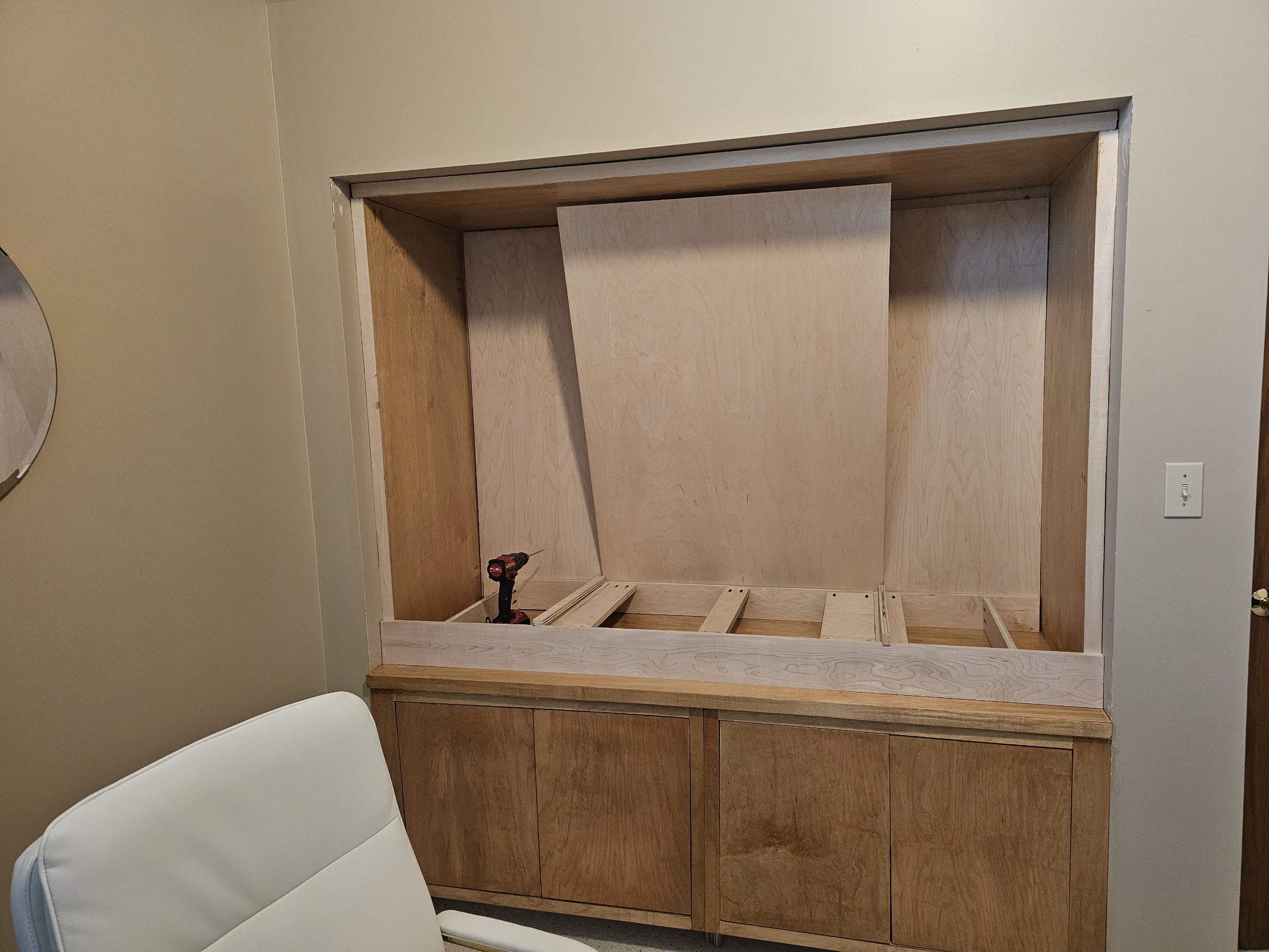 Partially rebuilt interior with a new raised floor frame and a large plywood panel leaning in place