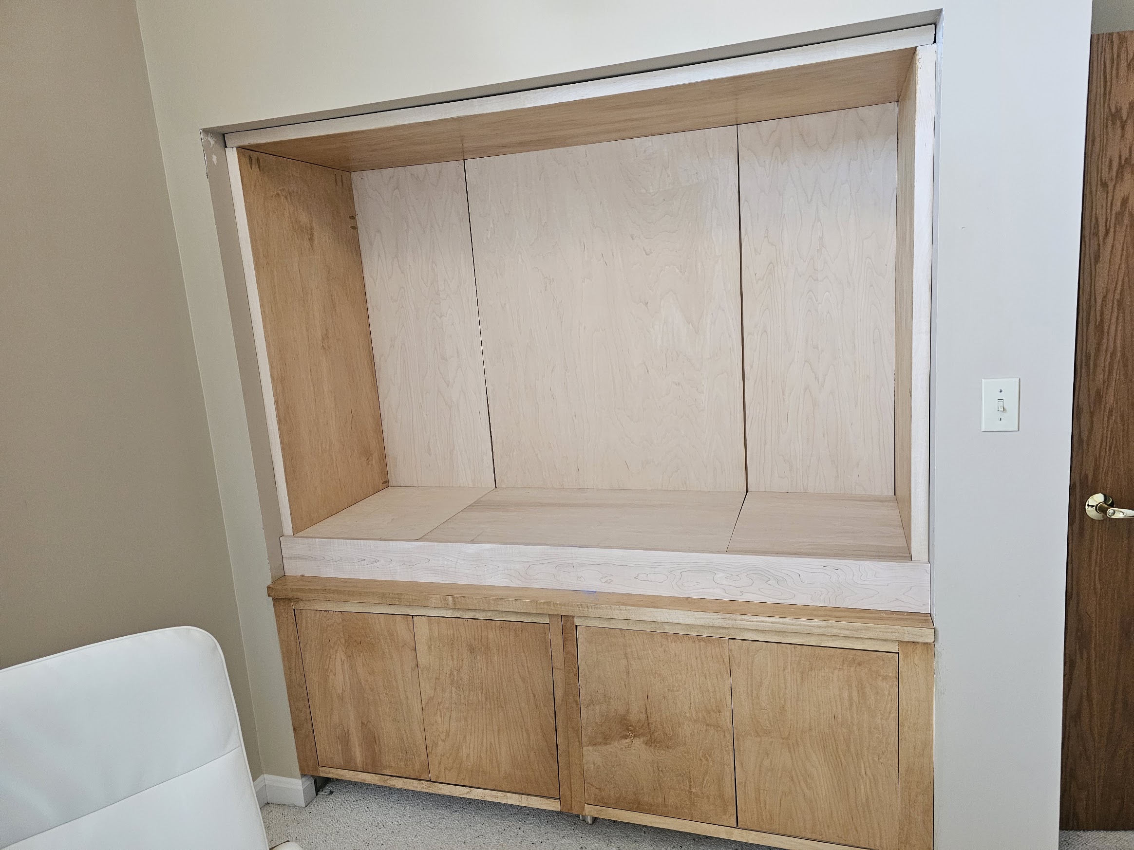 Finished plywood back wall in three clean panels above the new raised floor
