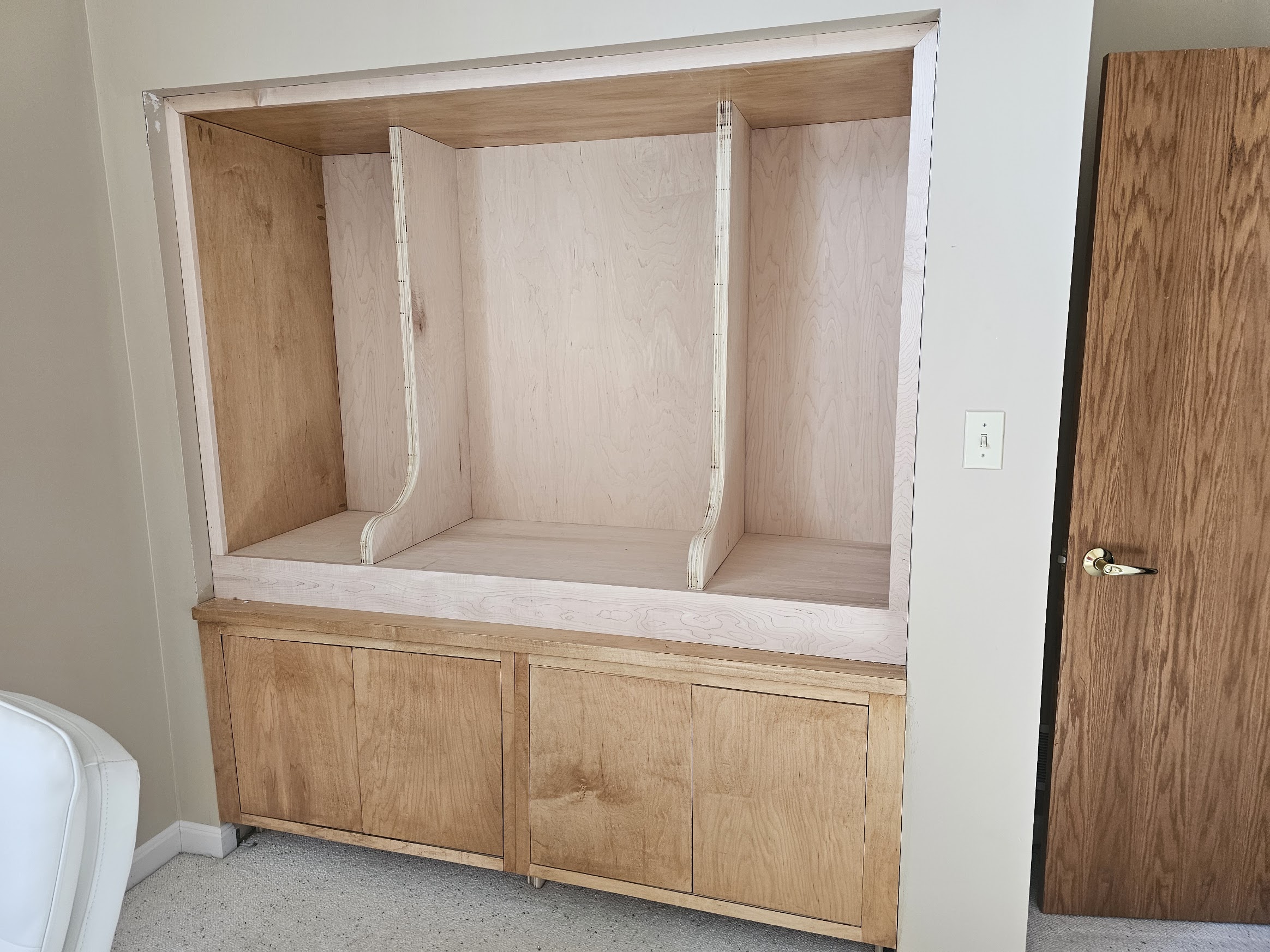 Built-in interior with two mirrored curved vertical dividers framing three bays