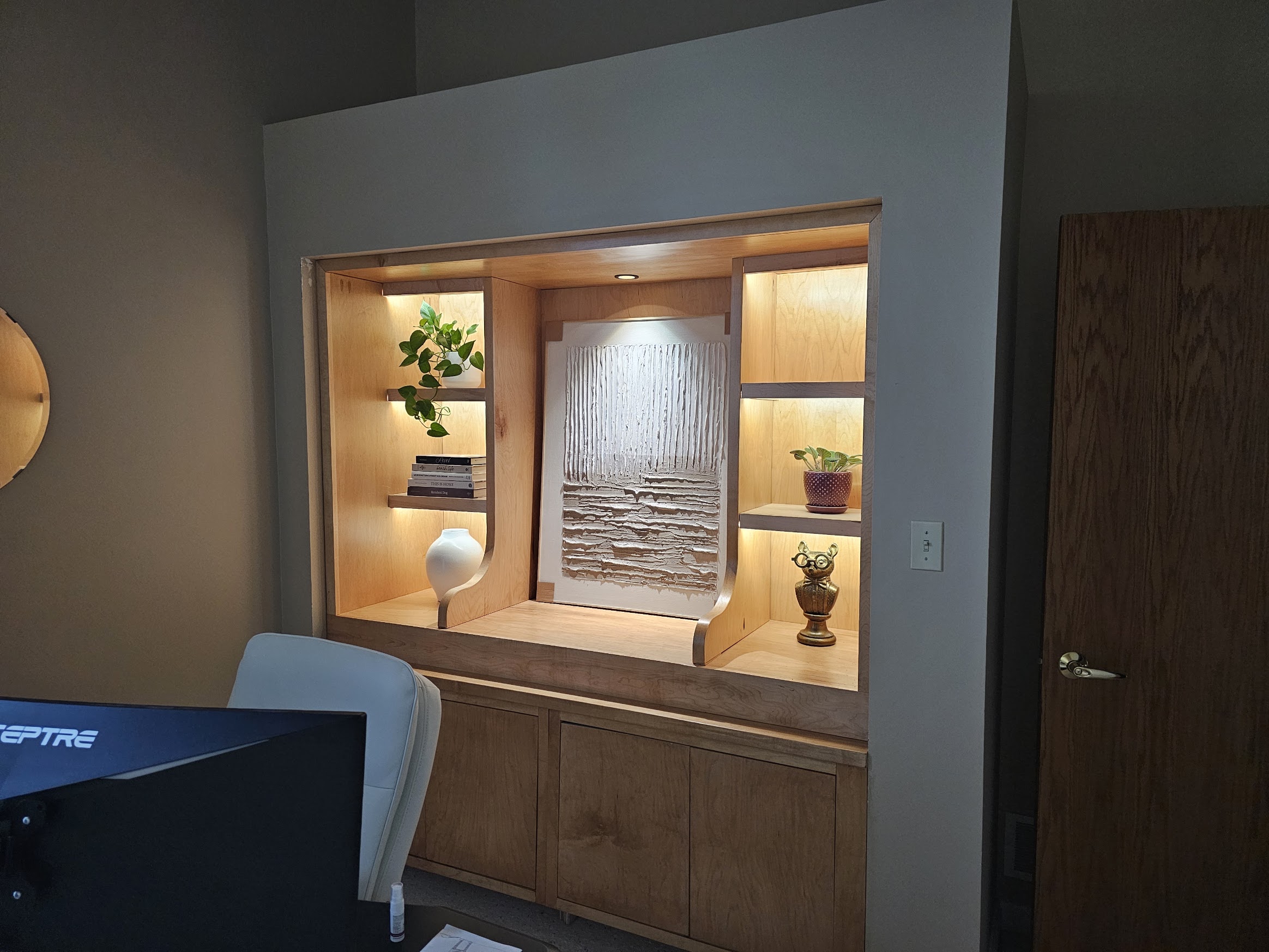 Built-in at night with warm shelf lighting glowing against dark walls