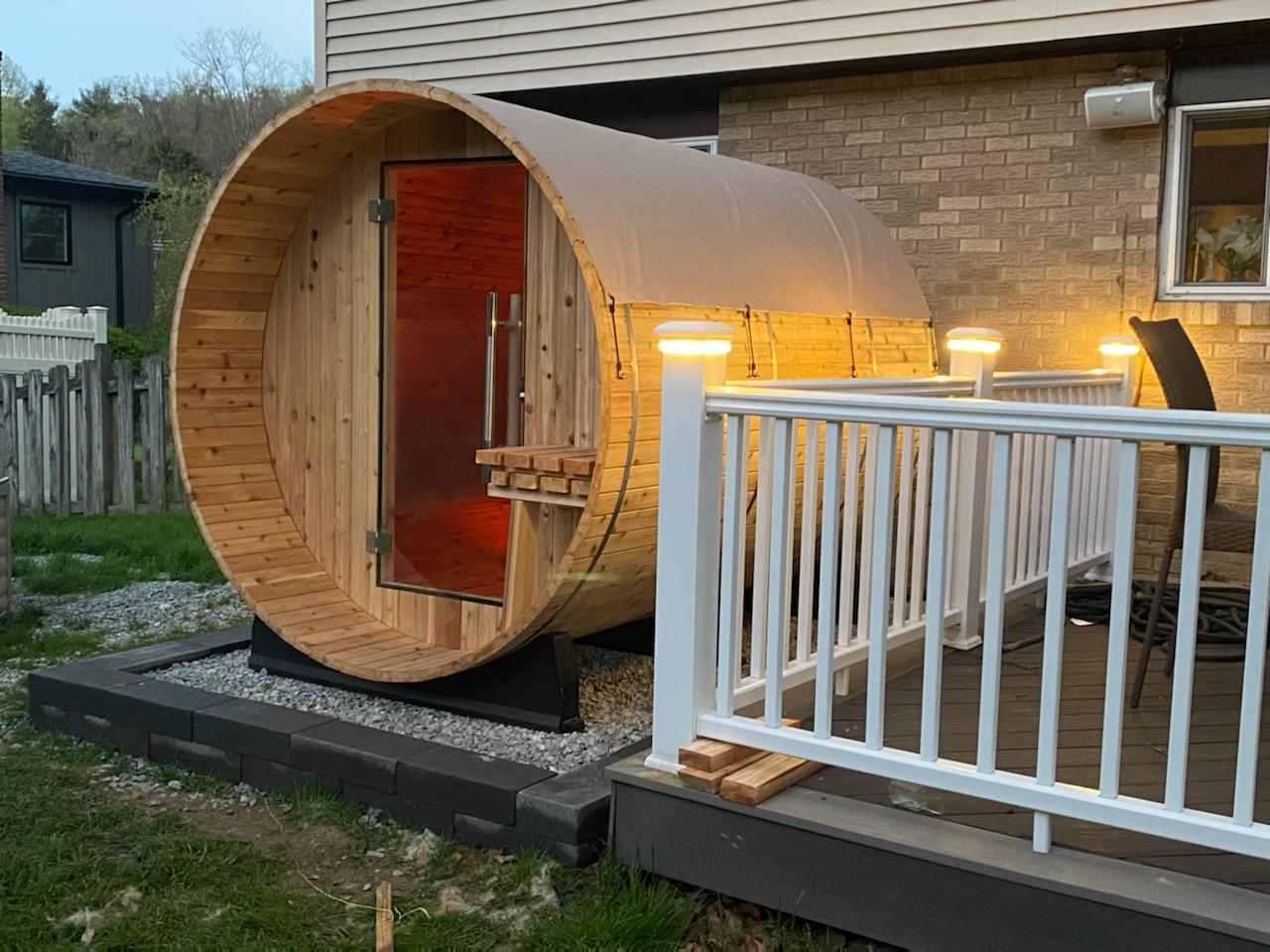 Deck lights on at dusk with barrel sauna